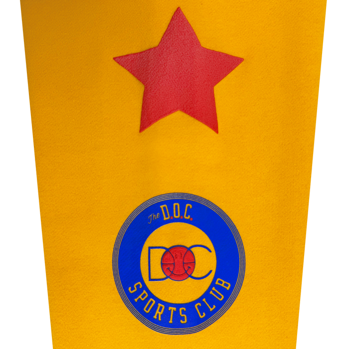 A yellow background with a red star at the top. Below, a blue and yellow circular logo reading “The D.O.C Sports Club” features a red basketball graphic and “DOC” text inside the circle—perfect as the centerpiece design on the Bay Bridge Hoodie by DOC from Other, or for an art project inspired by Bay Area culture.