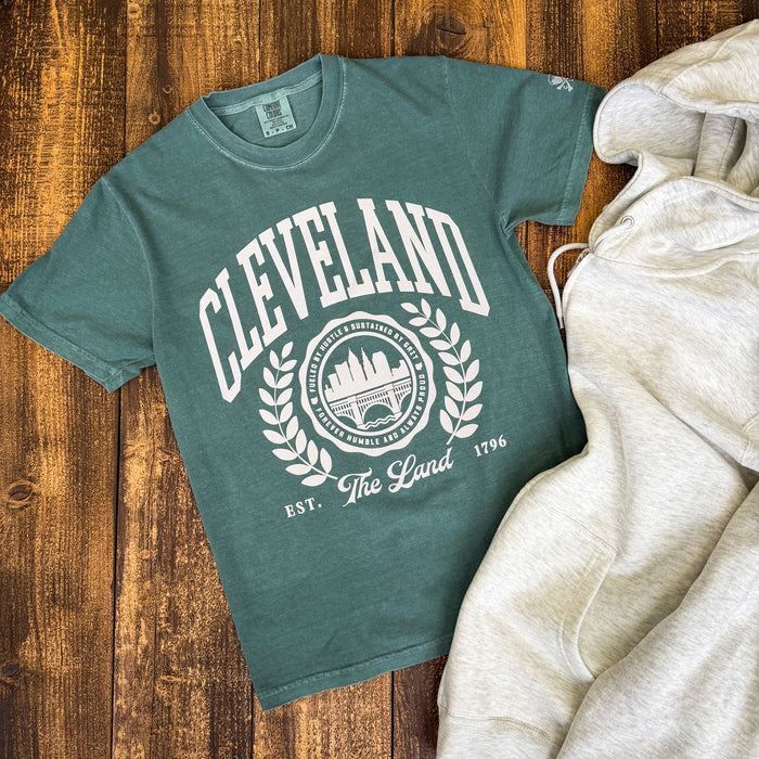 Green t-shirt with 'Cleveland' design on a wooden surface