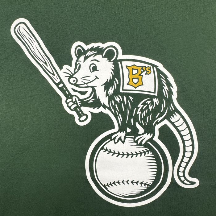 The Clutch Tee from Oakland Ballers features a cartoon opossum mascot holding a bat on a baseball, wearing a cape or jersey with a yellow "B's" logo—stands out on green, perfect for any pro baseball fan!.