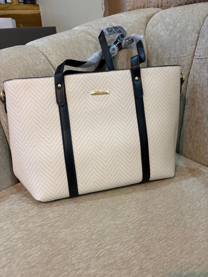 Cream herringbone woven tote bag with black leather straps and gold hardware