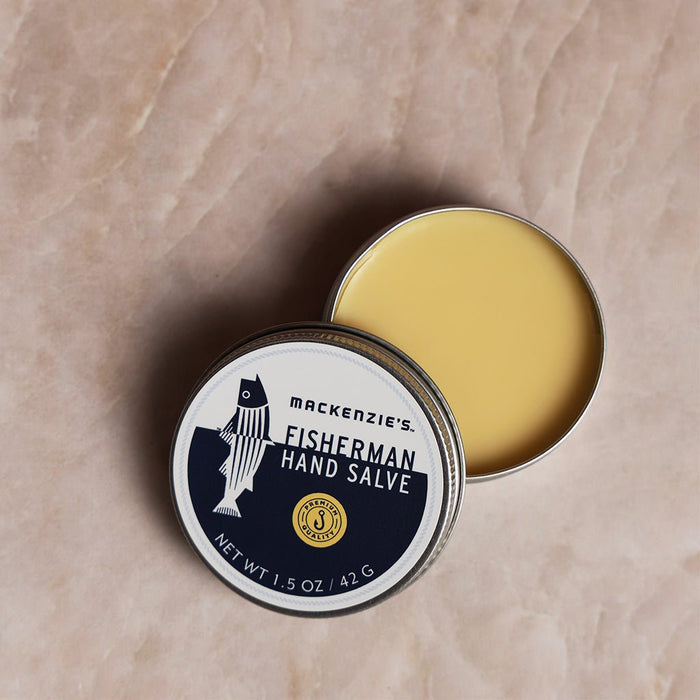 Open Mackenzie's Fisherman Hand Salve tin on a beige surface