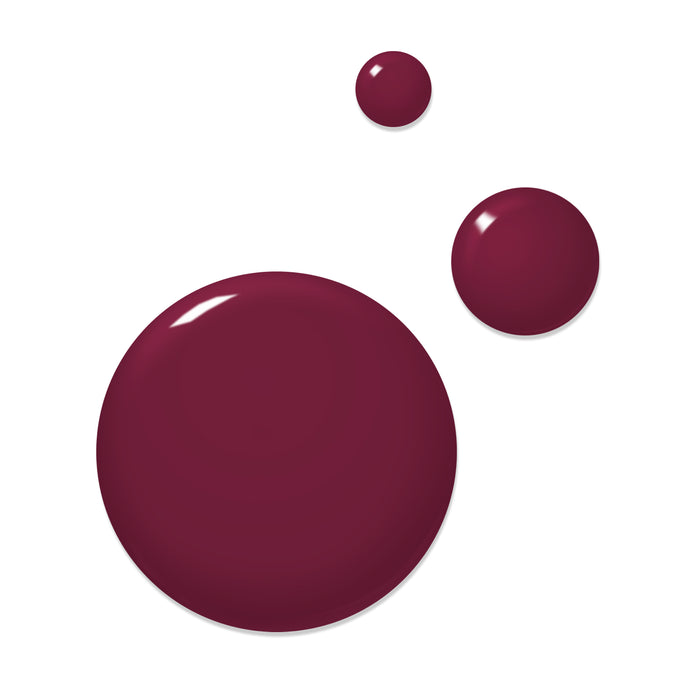 Three paint drops in the shade 'Flirty & Thriving' by LONDONTOWN, reminiscent of ripened raspberries, adorn a white background. The drops vary in size, with the largest at the bottom left and two smaller ones at the top right.