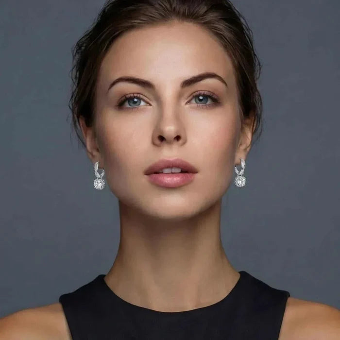Twisted Infinity Halo Moissanite Earrings in polished silver, featuring sparkling twisted tops and round stones framed by halos.