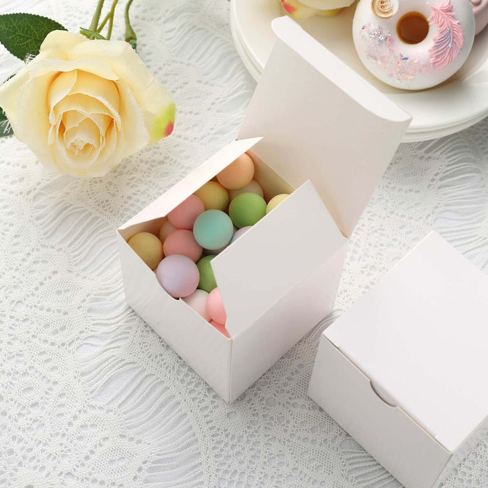 Colorful candy eggs in a white gift box on a delicate lace background.