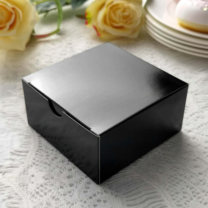 Black gift box with glossy finish on a lace tablecloth.