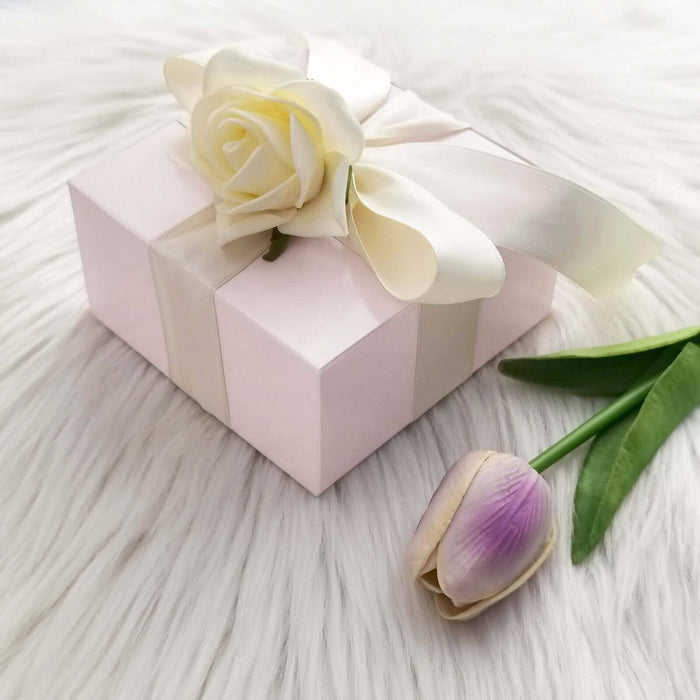 Elegant gift box with a rose and ribbon, surrounded by faux fur.