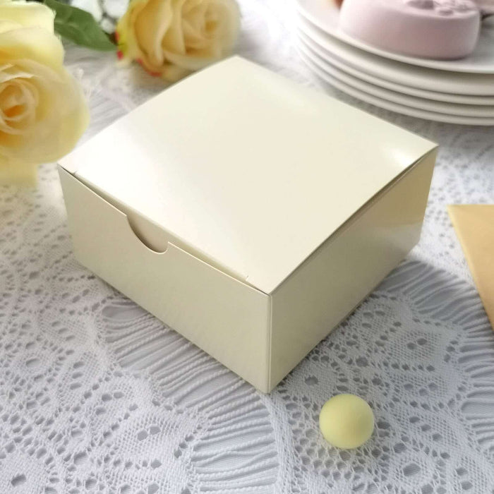 Cream-colored gift box with a sleek design on a lace tablecloth.