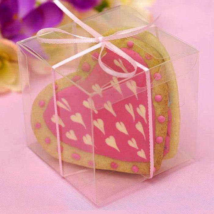 Heart-shaped cookie in a clear gift box with pink icing and decorative details.