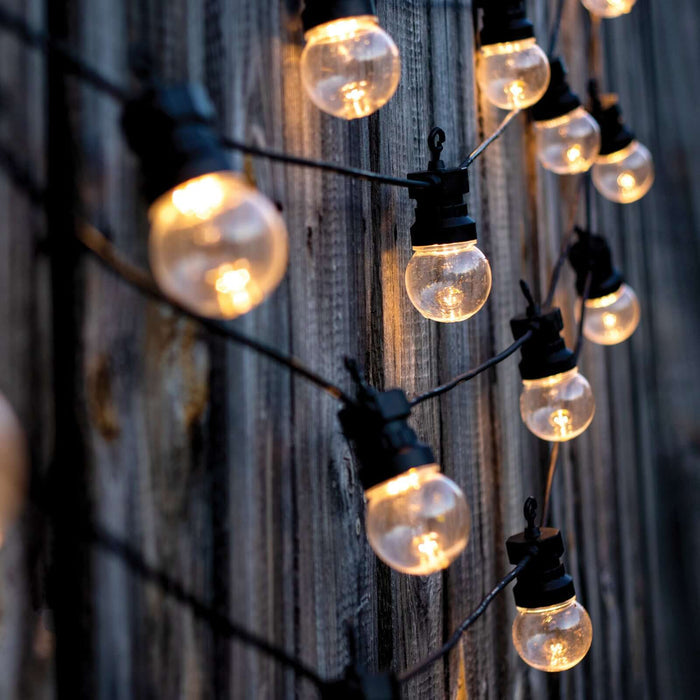 String lights hanging against a rustic wooden wall.