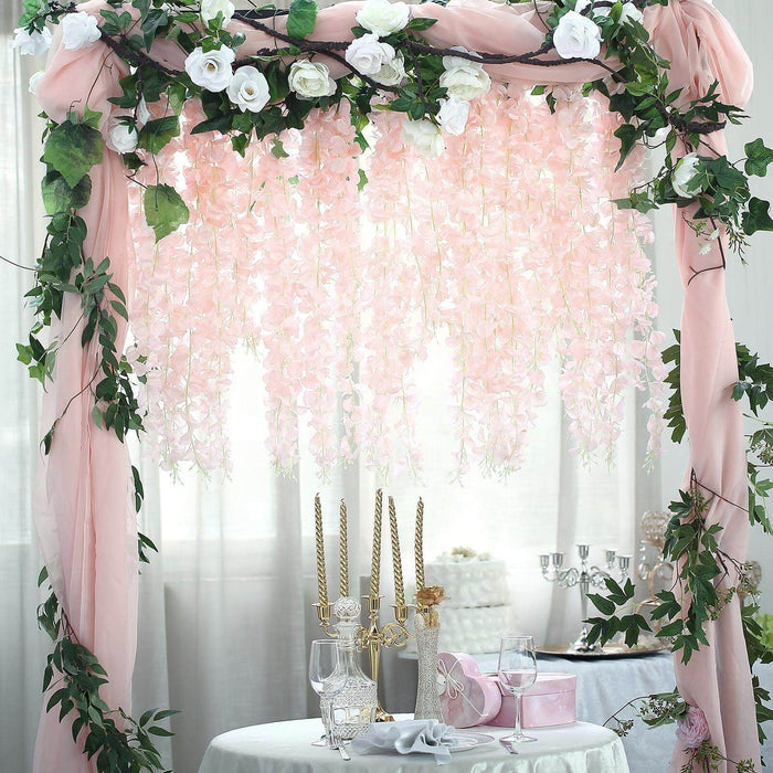 Floral wedding arch with pink flowers and greenery for event decoration.