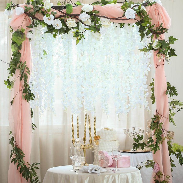 Wedding arch adorned with flowers and drapery for a romantic celebration scene.