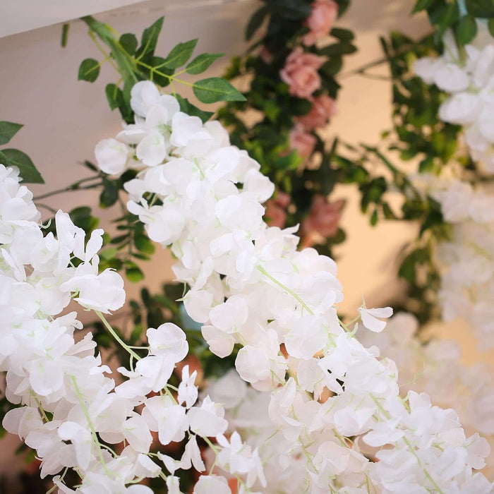 Artificial white floral garland with green leaves for decoration.