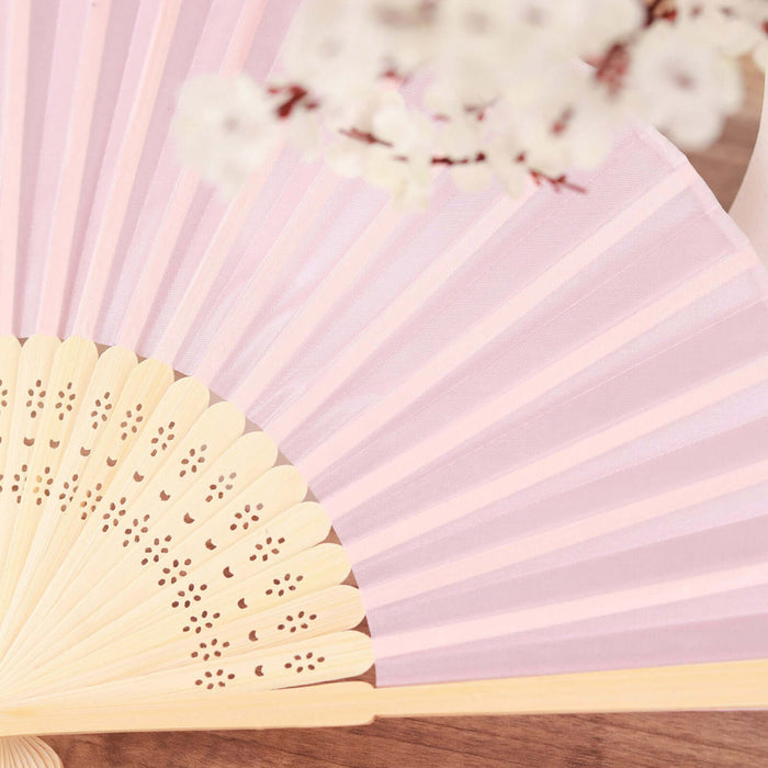 Pink decorative fan with wooden handle and intricate cutouts