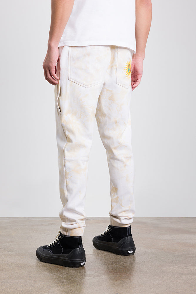 A person wearing 686 Mens Everywhere Double Knit Pant by 686, paired with black high-top sneakers and a white t-shirt, stands on a smooth floor facing away.