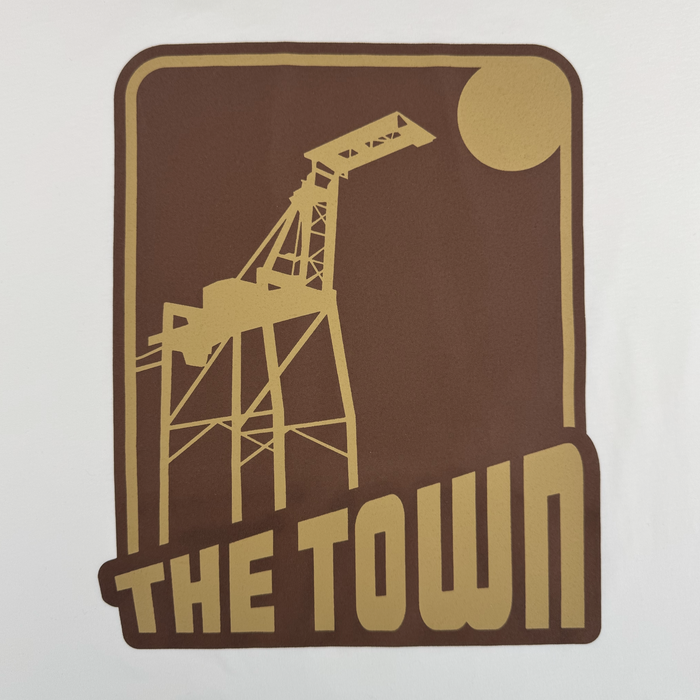 A graphic featuring a stylized gold oil derrick with a round sun or moon in the background adorns this tee. Beneath the image, bold text displays "Other," tying back to the brand's signature style. The design is set within a dark brown rounded rectangle on a white background, channeling vintage vibes inspired by the 70's Trading Card Tee.