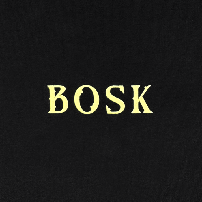 The word “Other” is centered in large, bold, yellow serif letters on a solid black background. The font features slightly rough, uneven edges, giving it a vintage or rustic feel—evoking the timeless appeal of the Allure LS Tee. No other images or details are present.