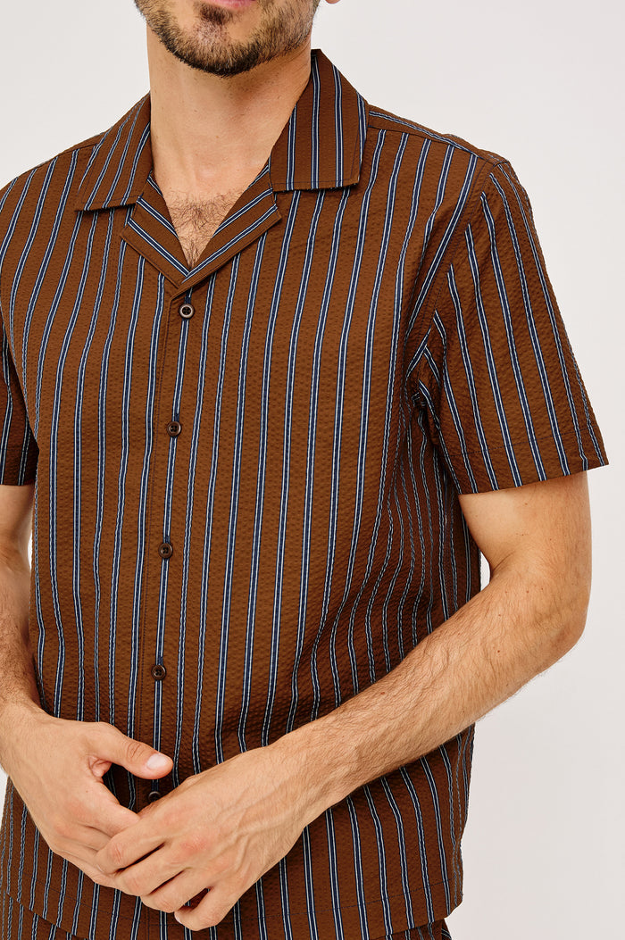 Amalfi Camp Shirt in Lightweight Seersucker With Notched Collar, Front Buttons, Short Sleeves, and Relaxed Fit in Rust Navy Stripe Colorway - Upper Body Front View Featured on Model