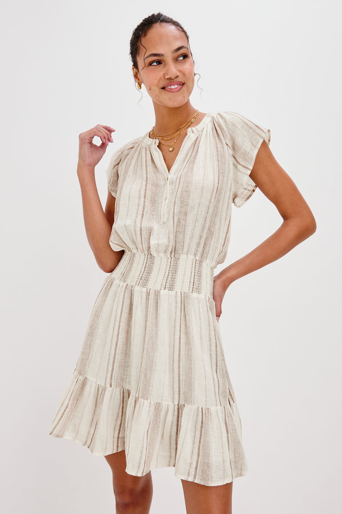 Augustine Mini Dress with Flutter Sleeves, V-Neck Button Front, Elastic Gathered Waist and a Tiered Flounce Hem in Jalisco Stripe Colorway. Front View Shown on Model.
