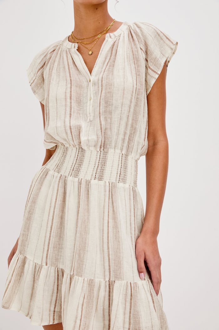 Augustine Mini Dress with Flutter Sleeves, V-Neck Button Front, Elastic Gathered Waist and a Tiered Flounce Hem in Jalisco Stripe Colorway. Front Detailed View Shown on Model.