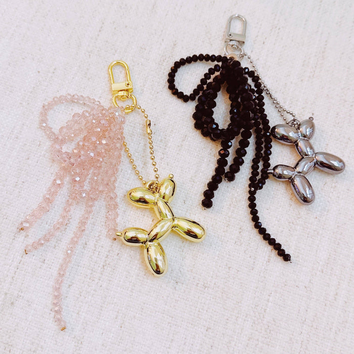 Ellison+Young balloon dog bag charm with beaded bow, decorative accessory for handbags, featuring a colorful, playful design.