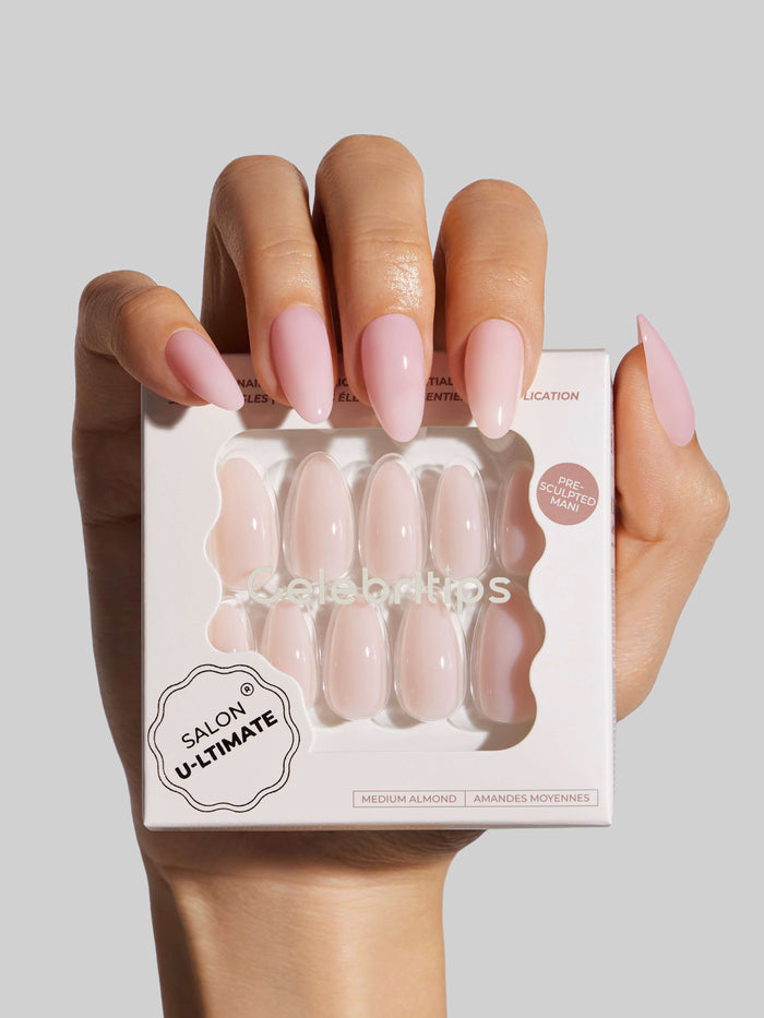 Hand holding a box of press-on nails with 'Salon Ultimate' branding on a light gray background
