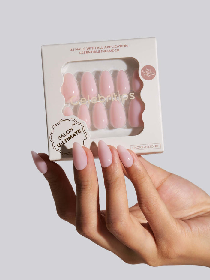 Hand holding a box of press-on nails with 'Salon U-ltimate' branding on a light gray background