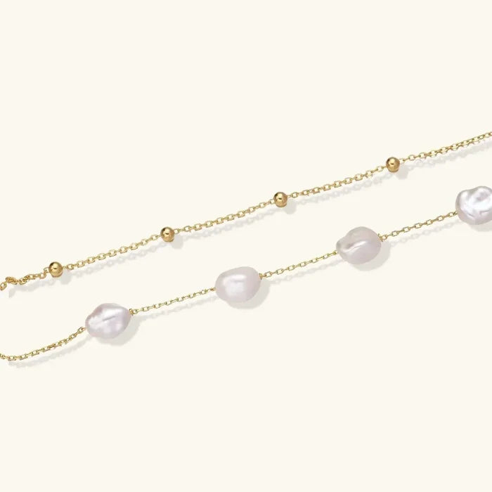 Baroque Pearl Layered Bracelet with two fine gold-tone chains, polished beads and irregular luminous white pearls