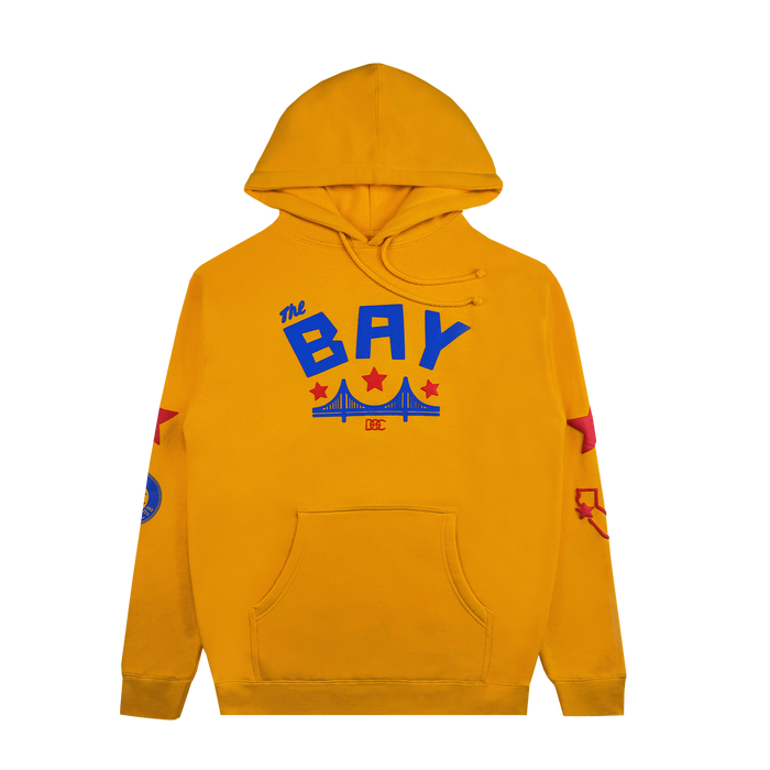 Introducing the Bay Bridge Hoodie by DOC from Other—a vibrant yellow designer hoodie featuring “The BAY” in blue and a bold red stylized bridge on the chest, perfectly capturing classic Bay Area energy. Eye-catching red stars and blue patches decorate the sleeves for an artful, creative vibe. This standout piece includes a front pocket and adjustable drawstring hood for comfort and style.