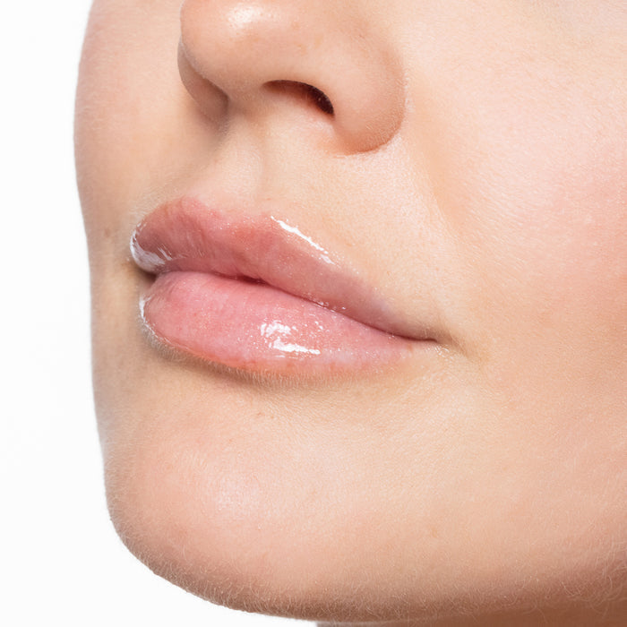 Close-up of a person's lips with a color sexy nude lip gloss