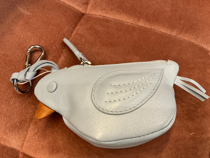 Colorful bird coin pouch charm by ili New York attached to a bag, featuring a vibrant bird design and playful details.