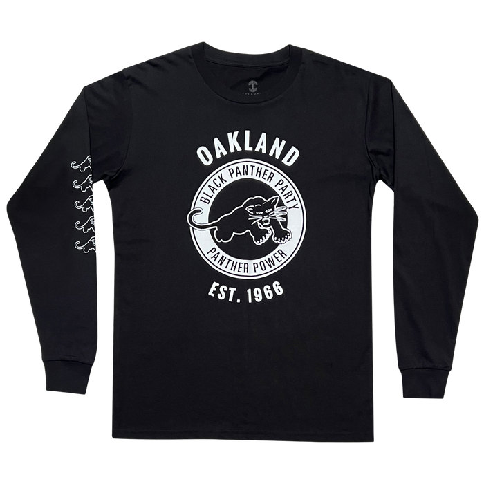 Introducing the Black Panther Power LS Tee by Oaklandish: This black long-sleeve shirt boasts a bold front design featuring a large circular emblem. Encircling an image of a panther in a striking pose is the text "OAKLAND BLACK PANTHER PARTY PANTHER POWER," celebrating the legacy of the party. Beneath this powerful graphic, it reads "EST. 1966." Additionally, a chain of panther images runs down one sleeve, adding an extra touch of style and homage.