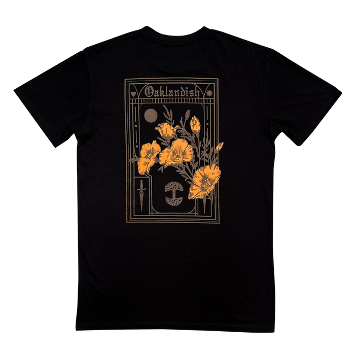 The "Blossom Tee" by Oaklandish is a black men's cotton t-shirt with a decorative design on the back, showcasing several yellow poppies—the California state flower—in front of a rectangular frame with art deco elements. The top of the frame reads "Oaklandish," and the bottom features stylized images of a sword and an ouroboros.