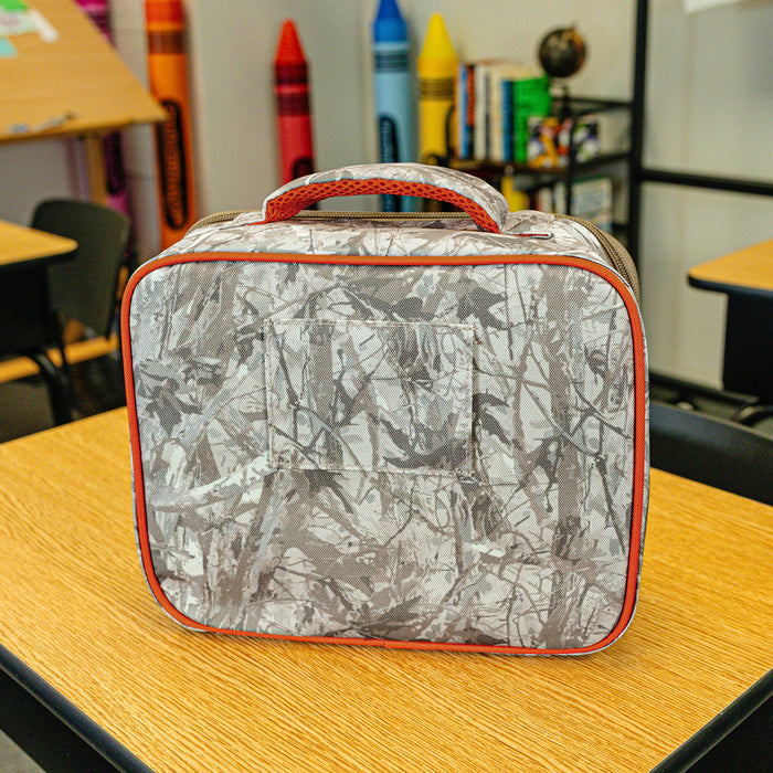 Adult model wearing multi-color lunch box with "Born To Fly SZN 2" design