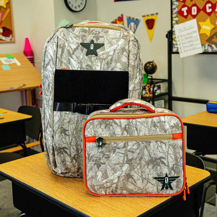 Adult model wearing multi-color lunch box with "Born To Fly SZN 2" design