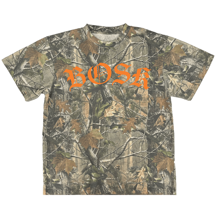Introducing the BOSK Camo Tee by Other—a heavyweight cotton short-sleeve t-shirt featuring a leafy forest tree camo pattern. Designed with an oversized fit for lasting comfort, it showcases “BOSK” printed in bold, bright orange Gothic-style letters across the chest. The t-shirt is displayed against a plain white background.