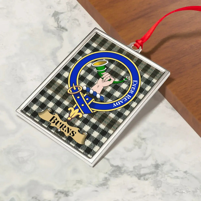 Burns ornament hanging from a Christmas tree branch by its satin ribbon