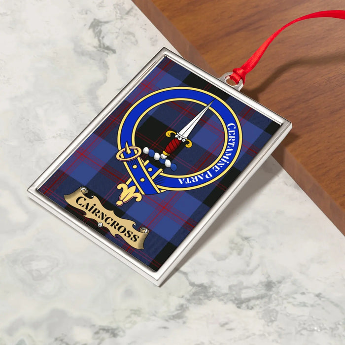 Cairncross ornament hanging from a Christmas tree branch by its satin ribbon