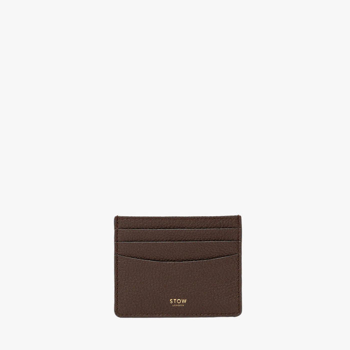 STOW London's Cardholder in Espresso pebbled leather on a light grey background featuring a fine gold embossed logo on the front bottom.