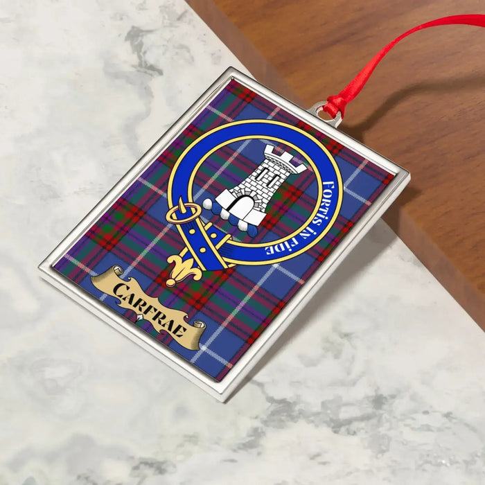 Carfrae ornament hanging from a Christmas tree branch by its satin ribbon