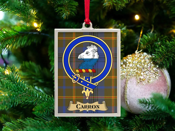 Carron clan crest Christmas ornament in a silver frame on a tartan background