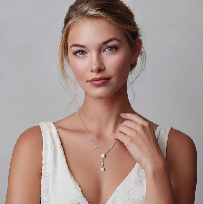 Celestial Balance Necklace in polished silver with delicate stone accents, a halo centrepiece and slender teardrop pendant