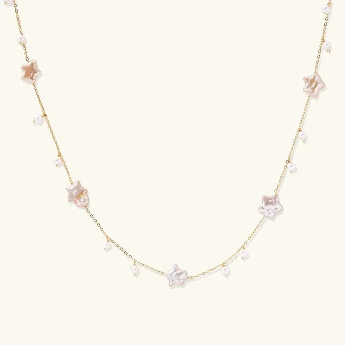 Celestial Pearl Stars Necklace with a fine gold-tone chain, pale pink-cream star-shaped pearls and small pearl drops