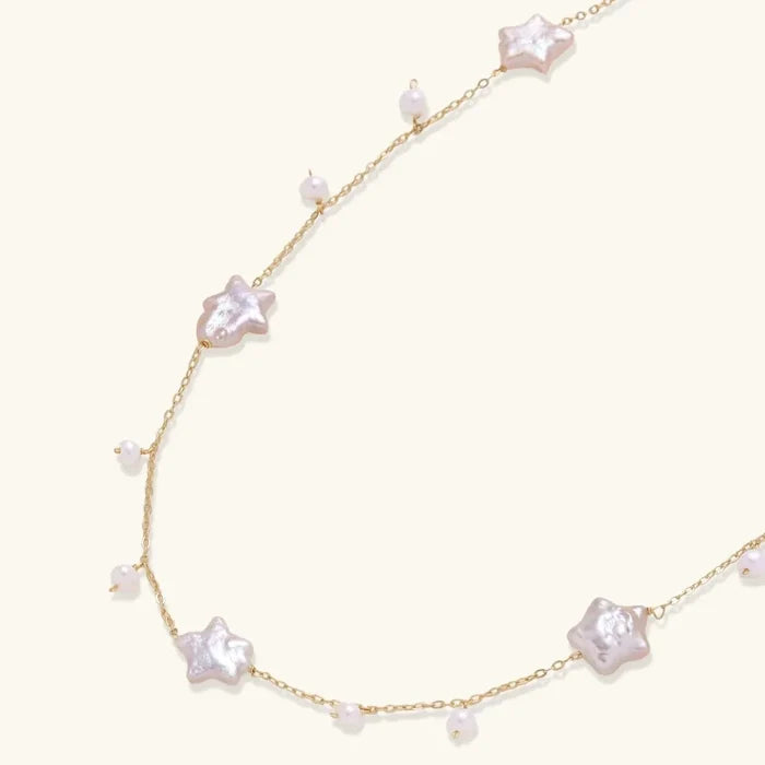 Celestial Pearl Stars Necklace in gold-tone chain with pale pink-white baroque star pearls and small pearl drops.