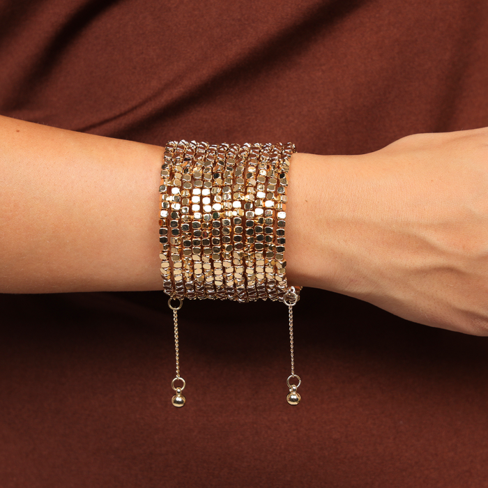 Champagne Omega Wrist Wrap by BuDhaGirl featuring warm gold cube beads in a textured multi coil bangle design with delicate dangling ends on a wrist