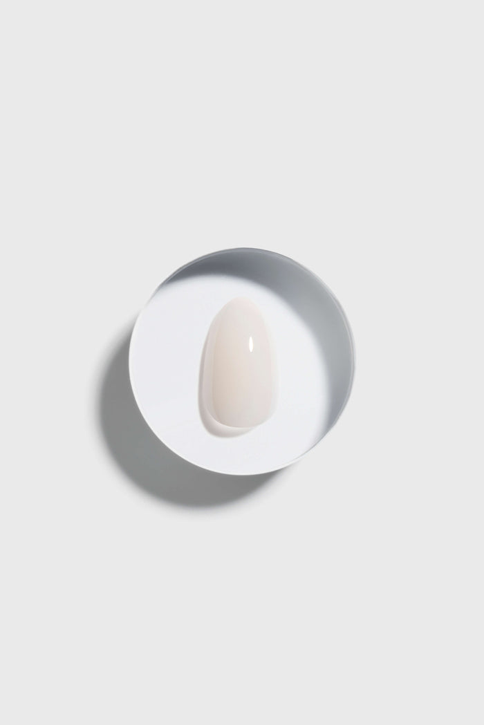 Coconut Milk press-on nail on a circular white plate with a gray rim against a light gray background