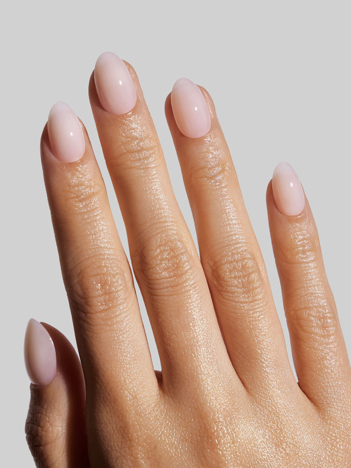Close-up of a hand with Coconut Milk press-on nails on a neutral background