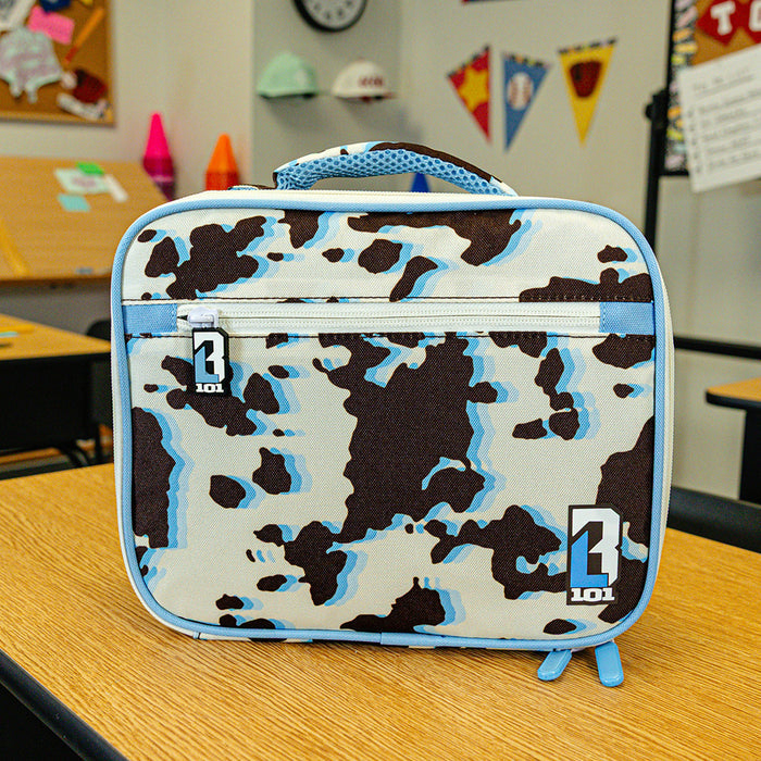 Adult model wearing multi-color lunch box with "Cowhide Curveball SZN 2" design
