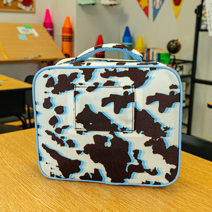 Adult model wearing multi-color lunch box with "Cowhide Curveball SZN 2" design