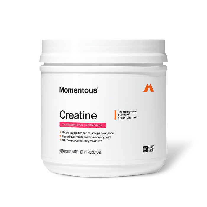 Front view of a Momentous Creatine tub, Watermelon Flavor, 60 Servings. White tub with white lid, Momentous logo and orange 'M' icon. Label reads 'Creatine' with pink Watermelon Flavor banner. 'The Momentous Standard Signature Spec' badge at top right. Benefits: supports cognitive and muscle performance, highest quality pure creatine monohydrate, ultrafine powder for easy mixability. Label shows: Dietary Supplement, Net Wt. 14 oz (396 g), NSF Certified Sport seal.