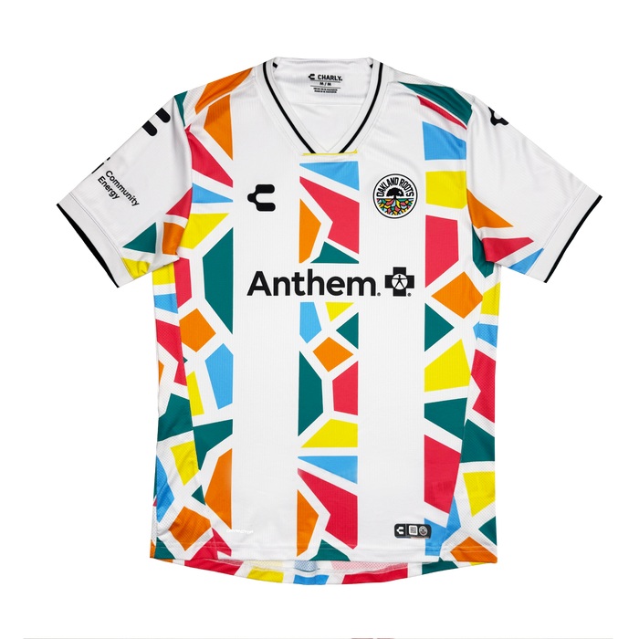 The Oakland Roots SC Custom Unisex Mosaic in Motion Kit is a white soccer jersey with a vibrant geometric pattern and black trim. It features the “Anthem.” sponsor logo and circular team badge—a standout 2026 secondary kit.